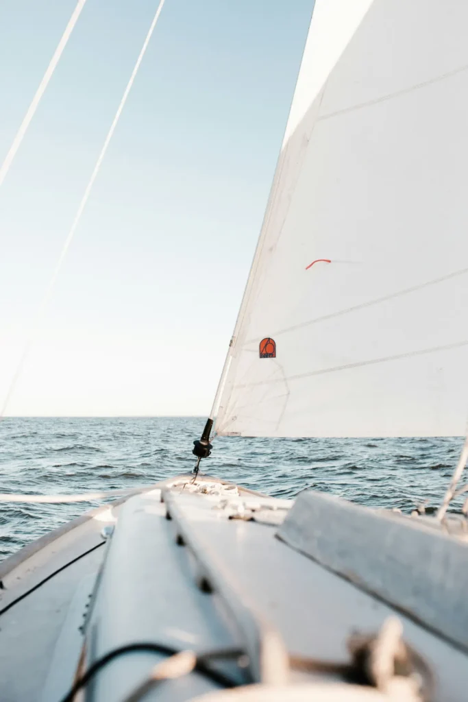 Vue depuis un voilier en mer, avec l'horizon et une voile d'avant complètement hissée